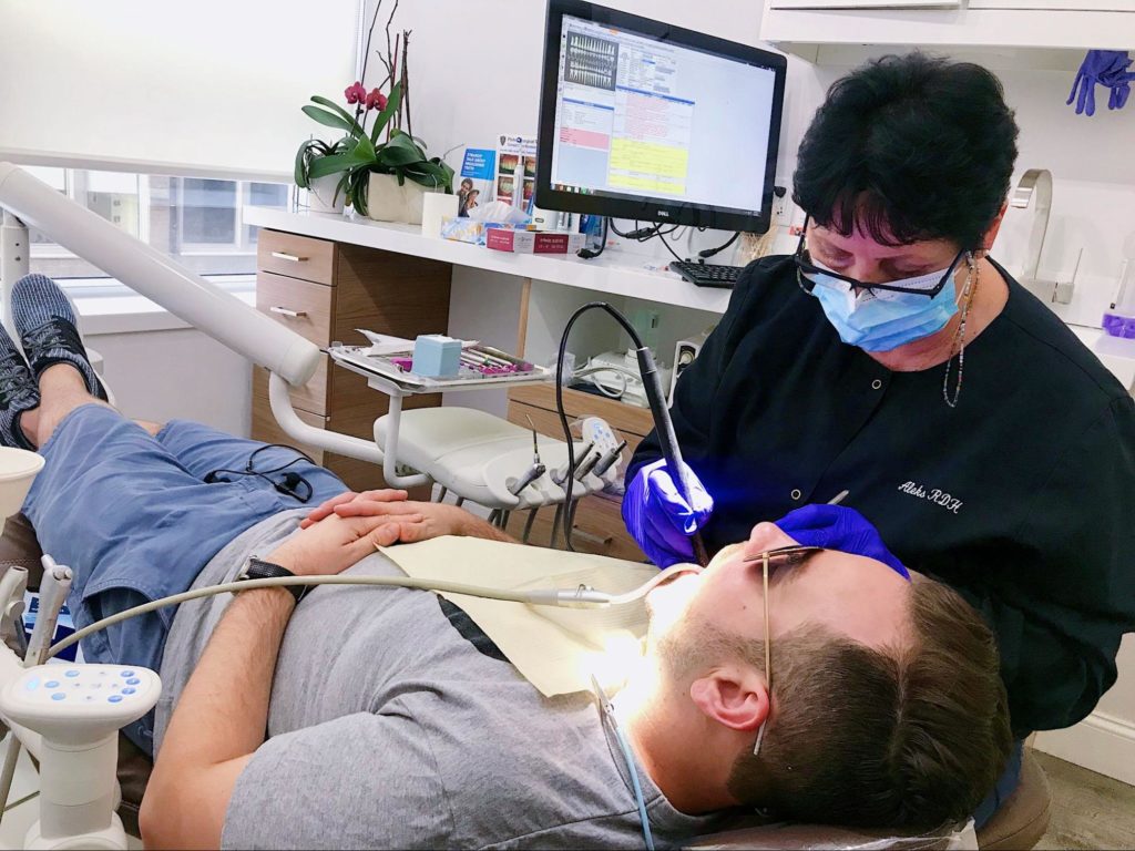 Our dental hygienist cleaning a patients teeth in office