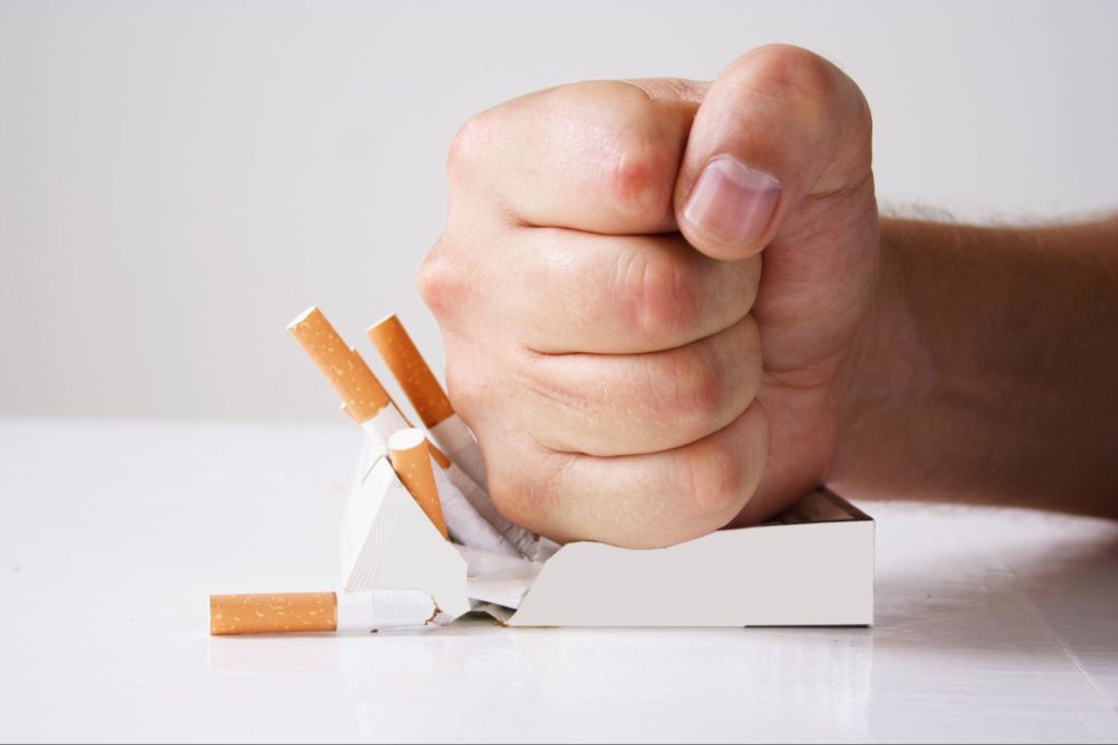 fist smashing a box of cigarettes